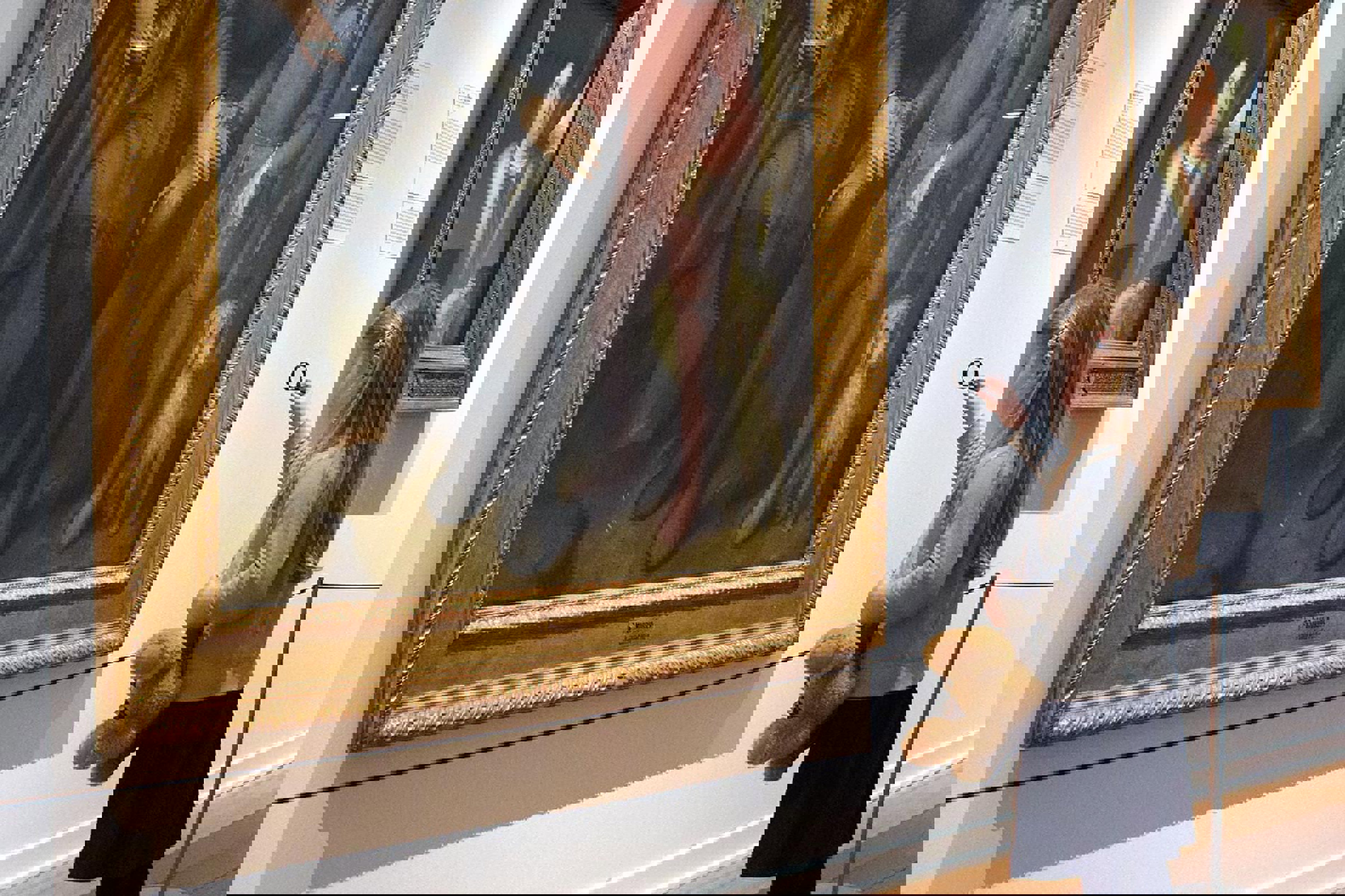 En kvinna tittar på målningar inne på Nivaagaard.