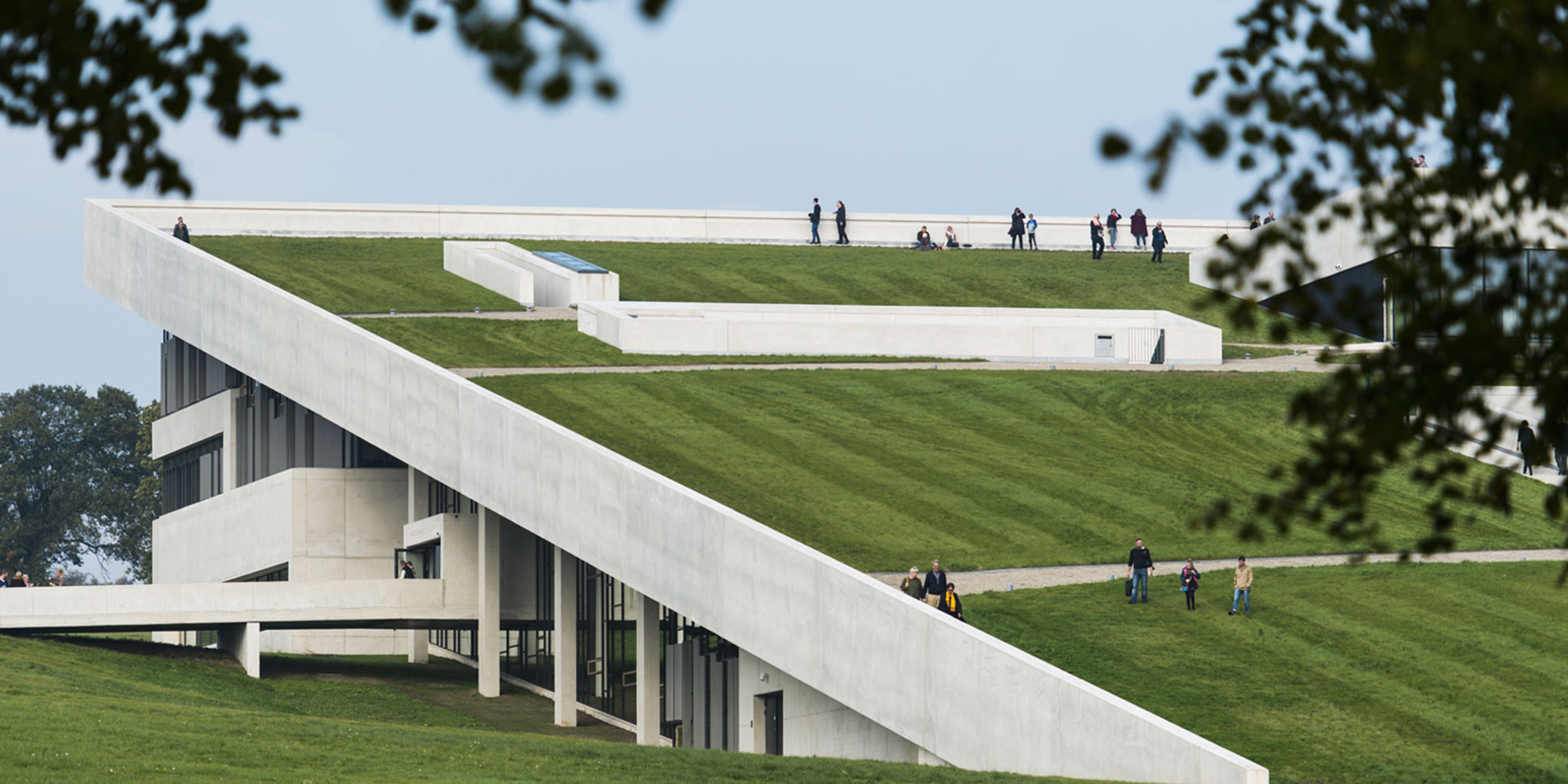 Taget af Moesgaard Museum ses med personer gående på de grønne arealer.