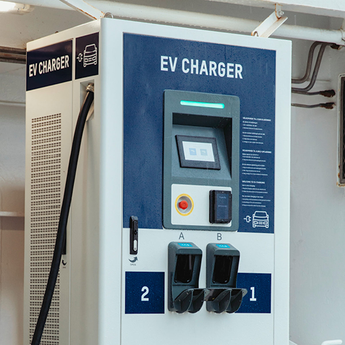 EV-laddare med dubbla uttag för elbilar på vit bakgrund i närbild.