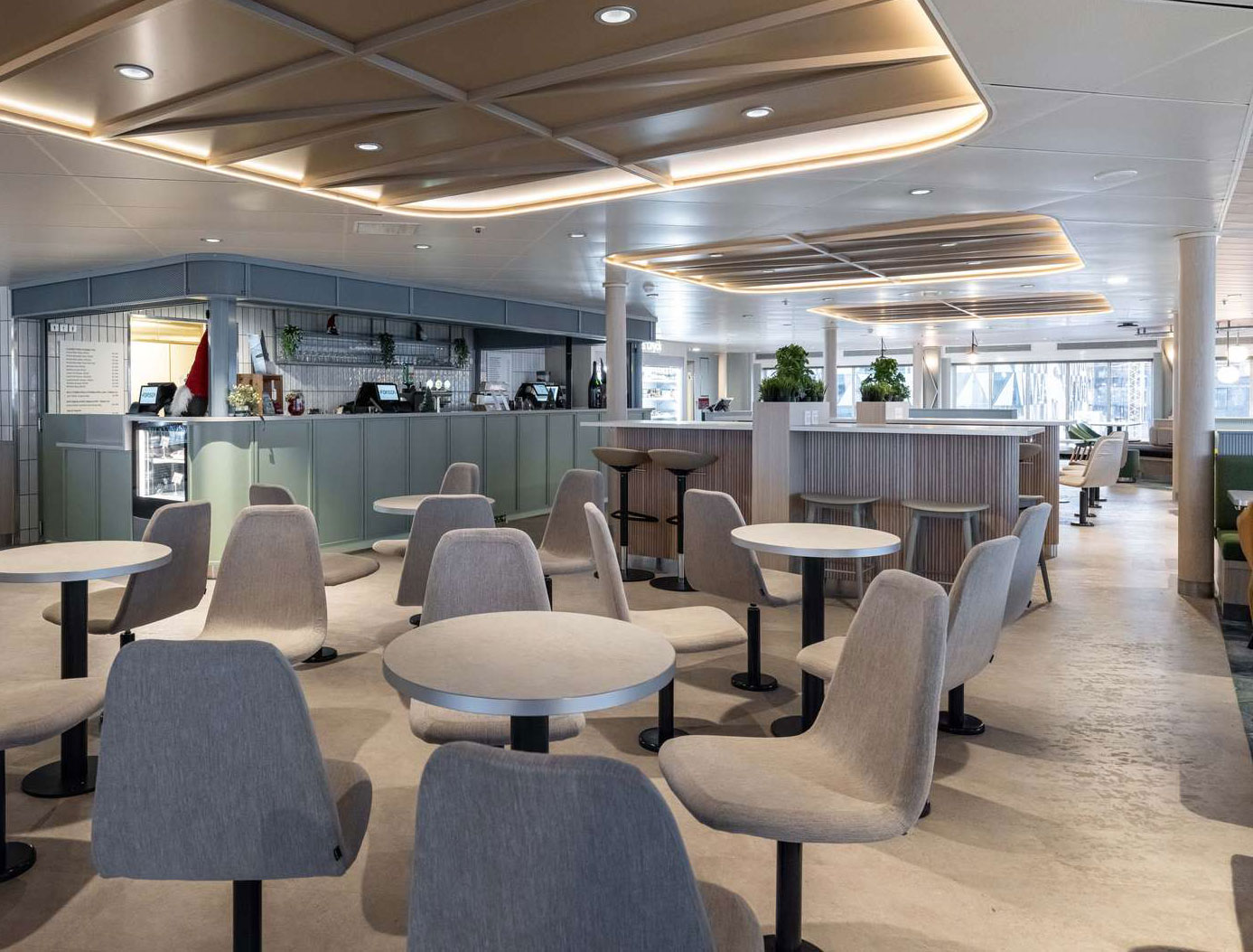 Moderna färjeinteriör med stilrena grå stolar och bord i passagerarområde, på en Molslinjen-färja.