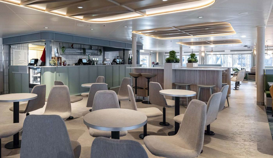 Moderne færgeinteriør med stilfulde grå stole og borde i passagerområde, set på en Molslinjen færge.