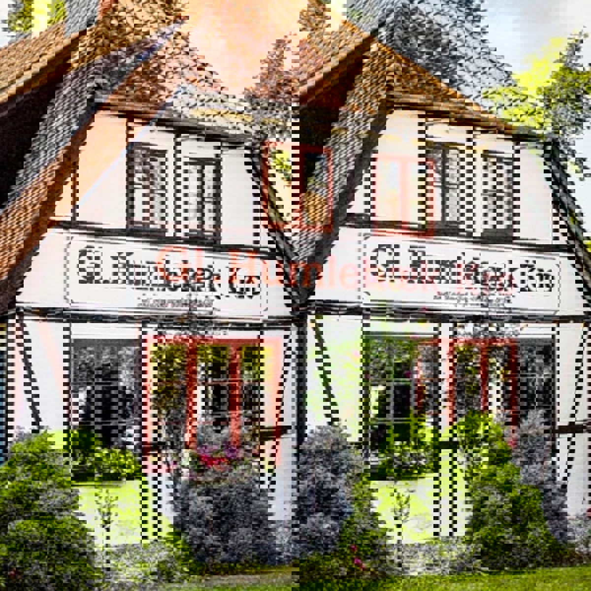 Humblebæk Kro sett från entrén med solsken, blå humla och gröna träd.