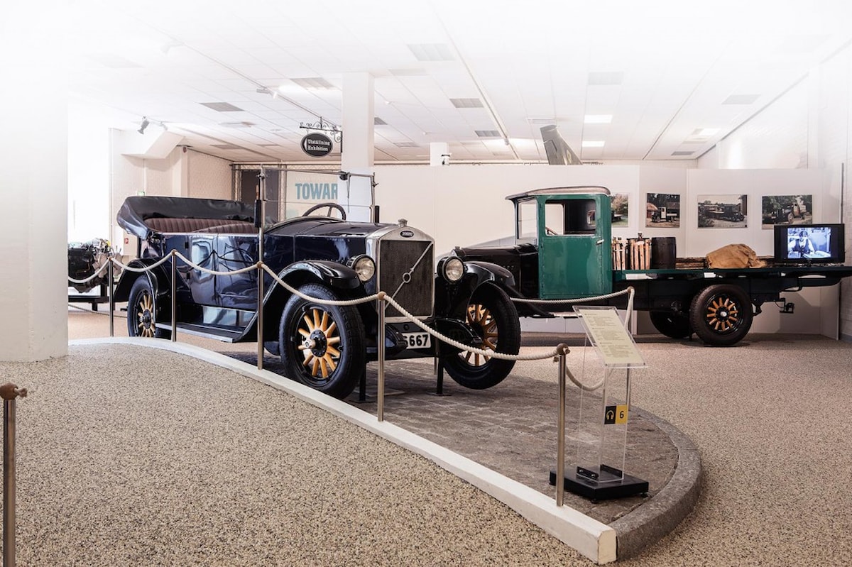 Indendørs ses flere gamle biler parkeret med museumsbånd omkring.