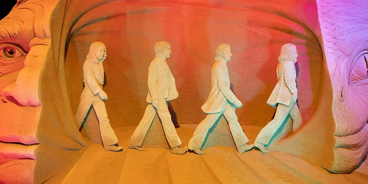 Sandskulptur av fyra personer som promenerar, Hundested Sandskulptur 22 Tidslinje-utställning.