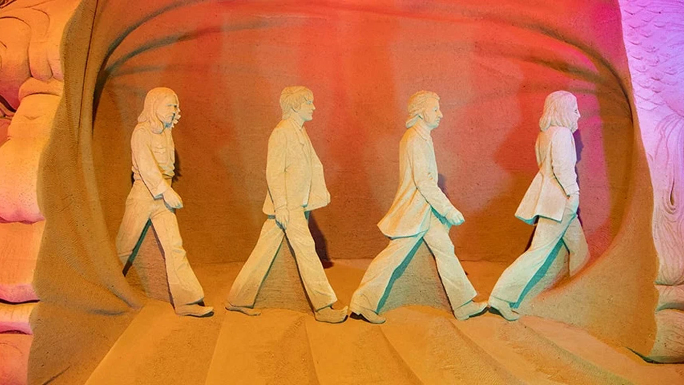 Sandskulptur av fyra personer som promenerar, Hundested Sandskulptur 22 Tidslinje-utställning.