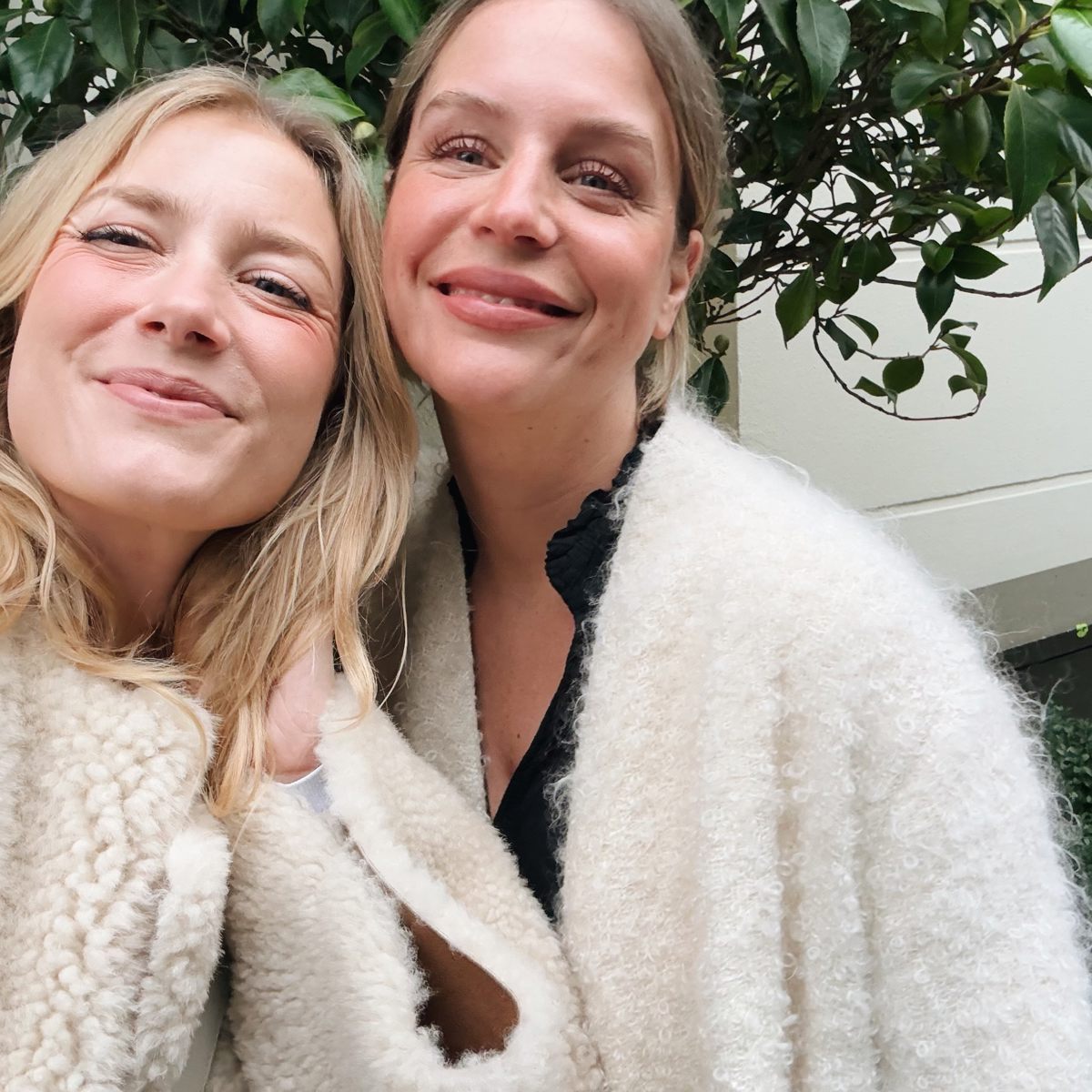 Två flickor ler i en selfie.