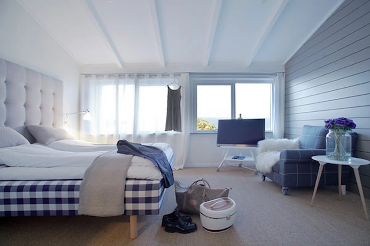 Avkopplande Gilleleje badehotel sovrum med bekväm säng, stora fönster och ljus inredning.