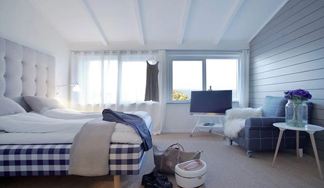 Avkopplande Gilleleje badehotel sovrum med bekväm säng, stora fönster och ljus inredning.