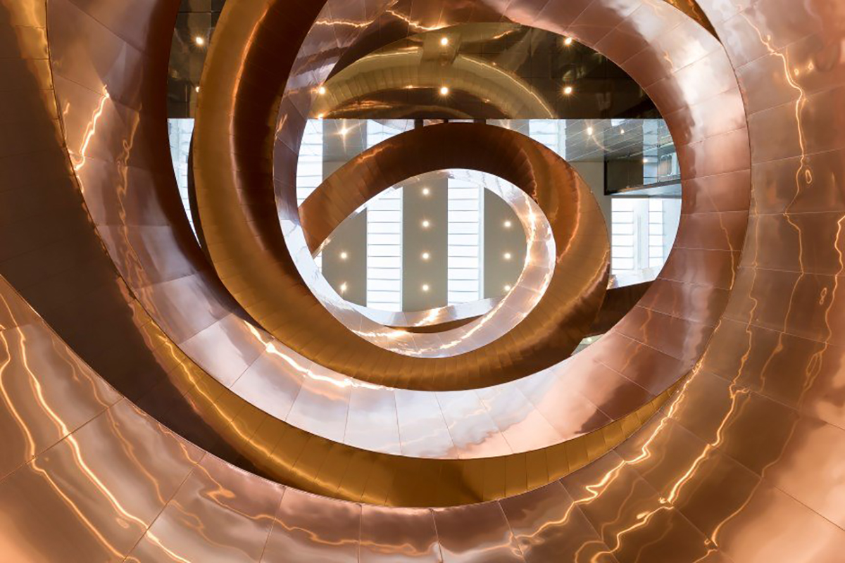 Experimentariums spiralskulptur på utställningsgolvet, med besökare som promenerar runt den unika designen.