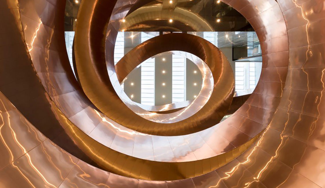 Experimentariums spiralskulptur på utställningsgolvet, med besökare som promenerar runt den unika designen.