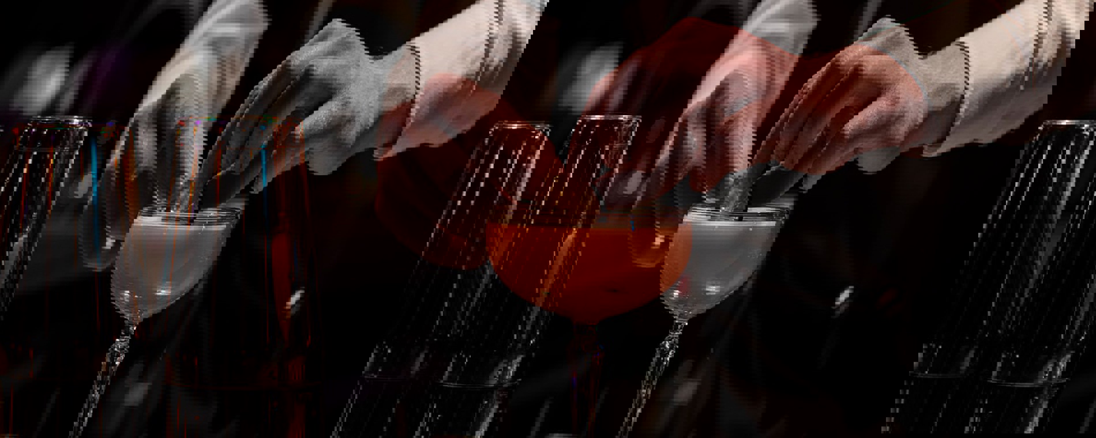 En bartender er ved at færdiggøre en drink med garnish.