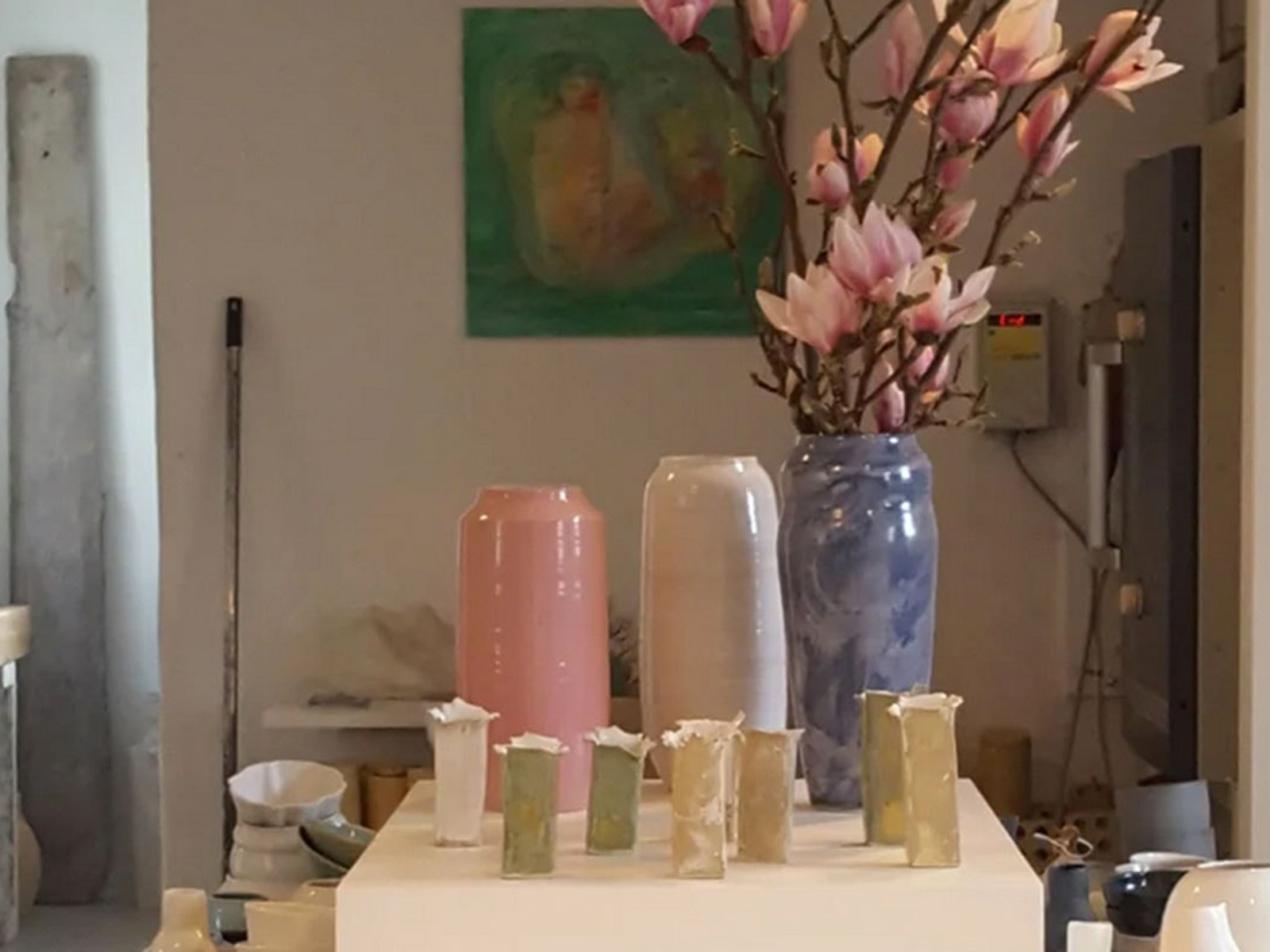 Keramikvaser i Galleri Nordrum med blommande magnoliakvistar i en marmorblå vas, omgivna av rosa och vita vaser.