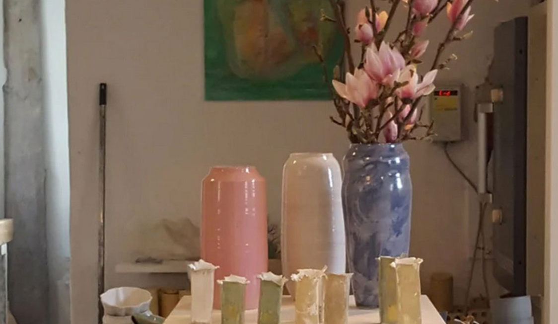 Keramikvaser i Galleri Nordrum med blommande magnoliakvistar i en marmorblå vas, omgivna av rosa och vita vaser.