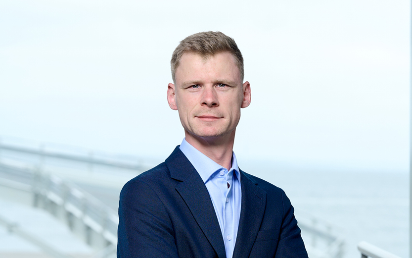 Nichlas Hoejgaard COO i mørkeblå jakke udendørs med ocean i baggrunden.