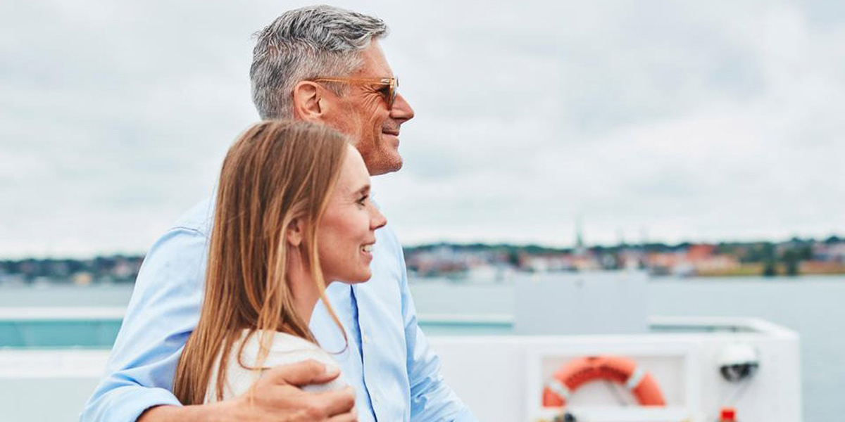 Par nyder udsigten fra færgen mod horisonten på en overskyet dag.