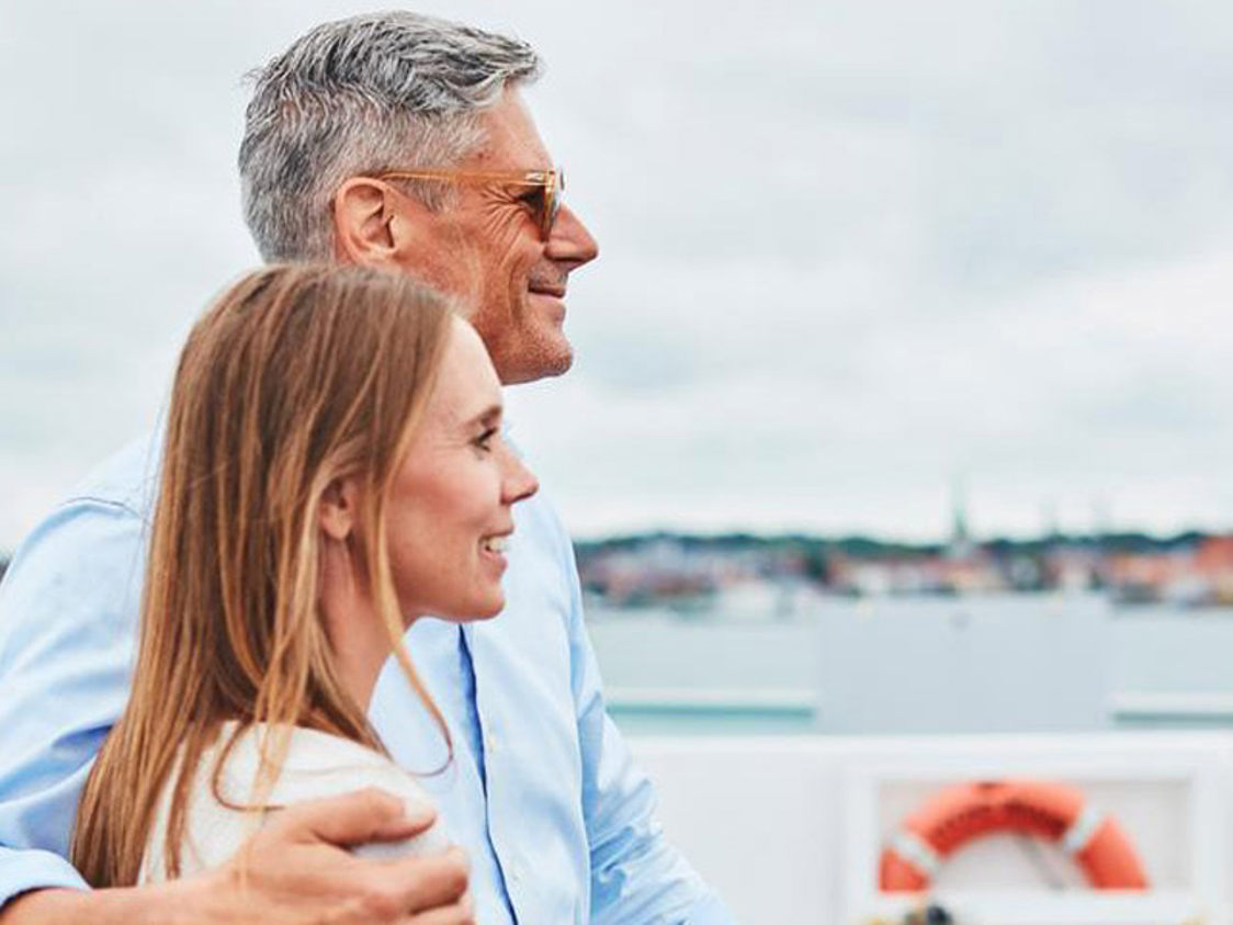 Par nyder udsigten fra færgen mod horisonten på en overskyet dag.