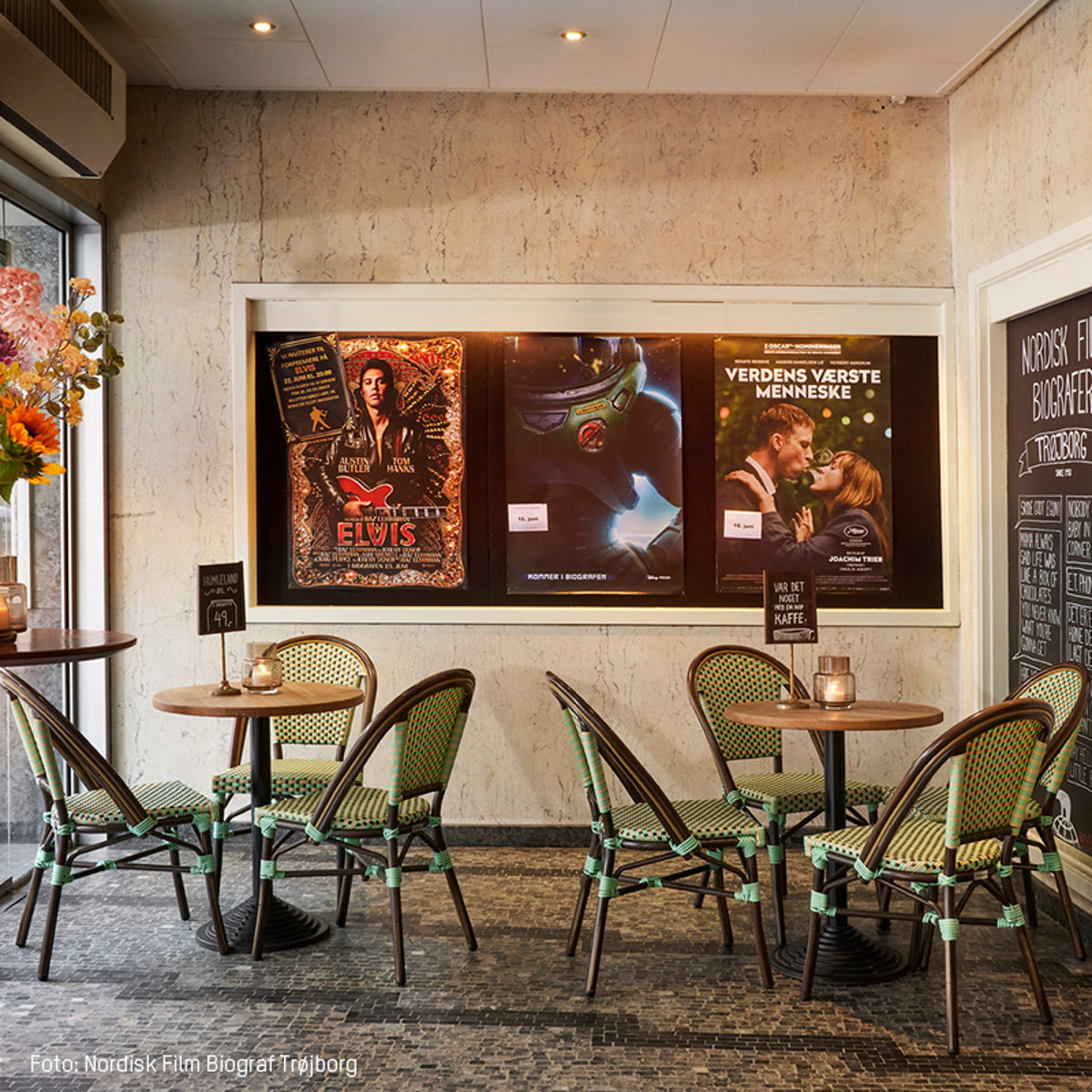 Biografens caféområde med plakater fra filmene Elvis, Verdens Værste Menneske og en science fiction-film på væggen.