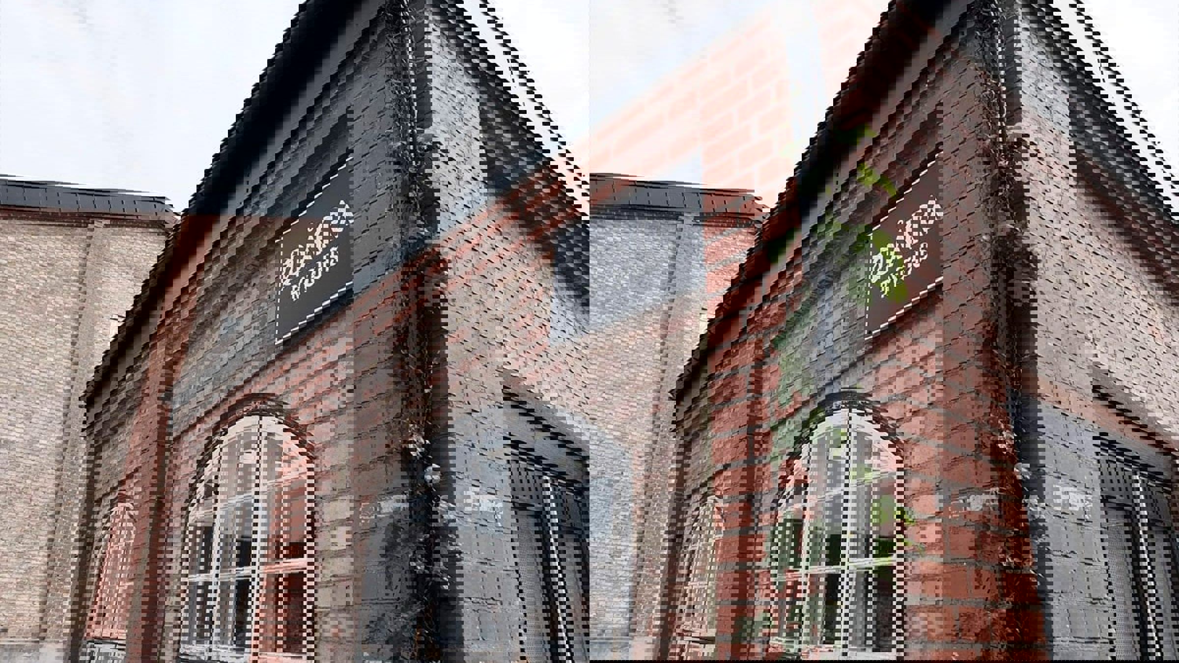 Shoppingcenter Spritfabriken Brygghus set fra gadeplan med tydelige butikskonstruktioner i fokus.