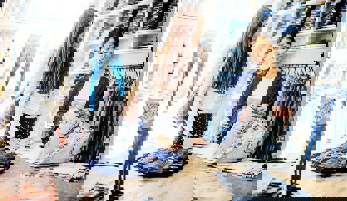 To kvinder kigge rpå tøj i en svensk tøjbutik.