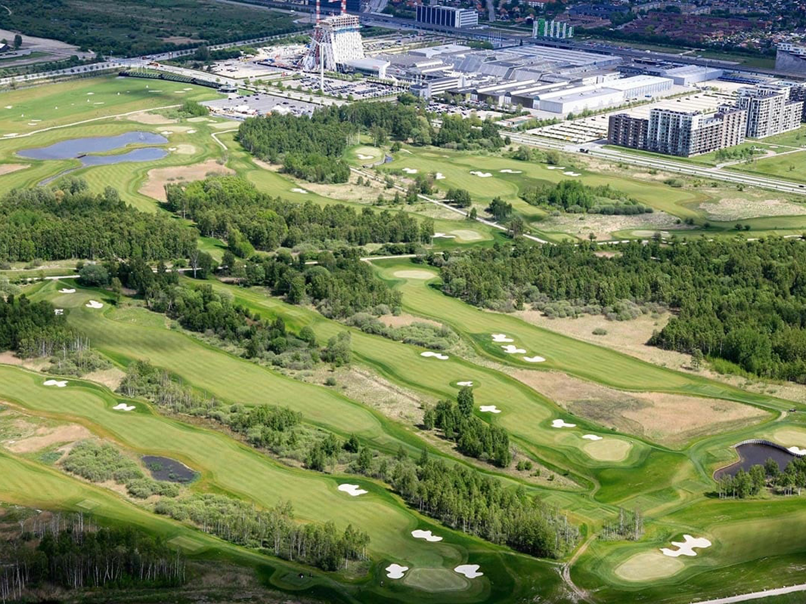 Royal Golf Club från ovan visar frodig grönska och elegant designad golfbana omgiven av skog.