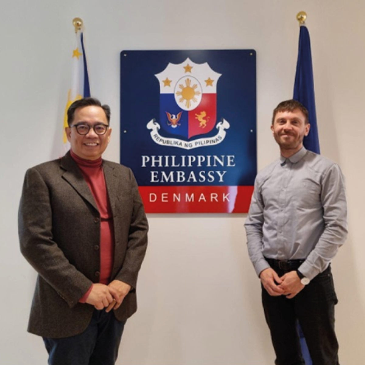 To personer står foran skiltet til Filippinernes ambassade i Danmark.