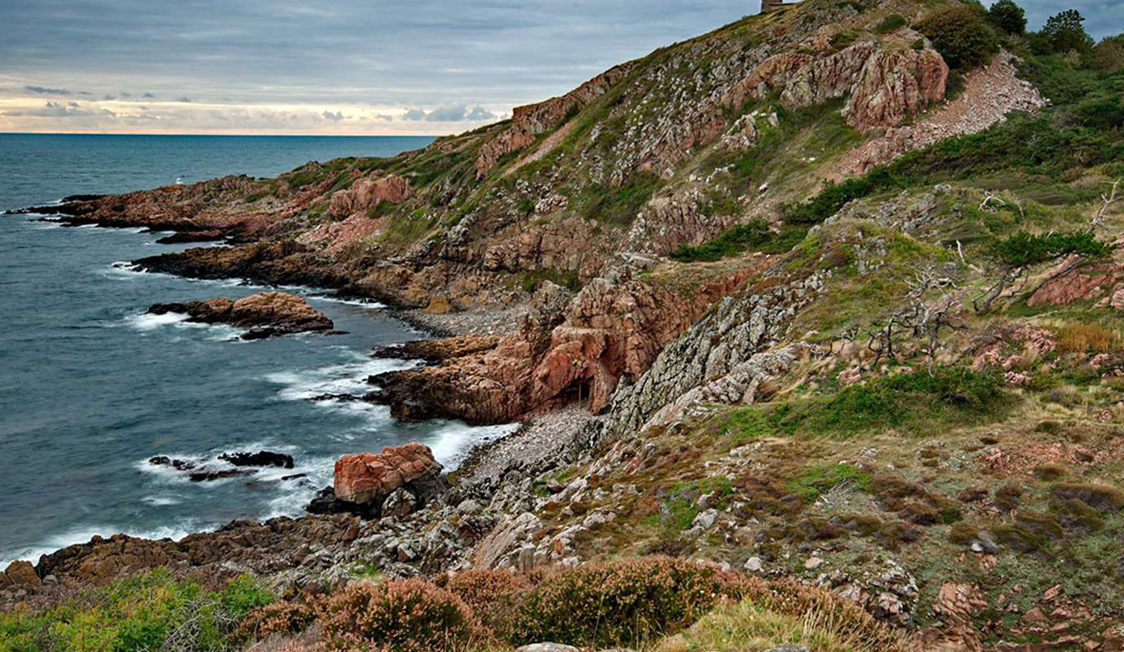 Klipper og strand ved Kullen i Sverige set fra vandkanten med udsigt til det åbne hav.