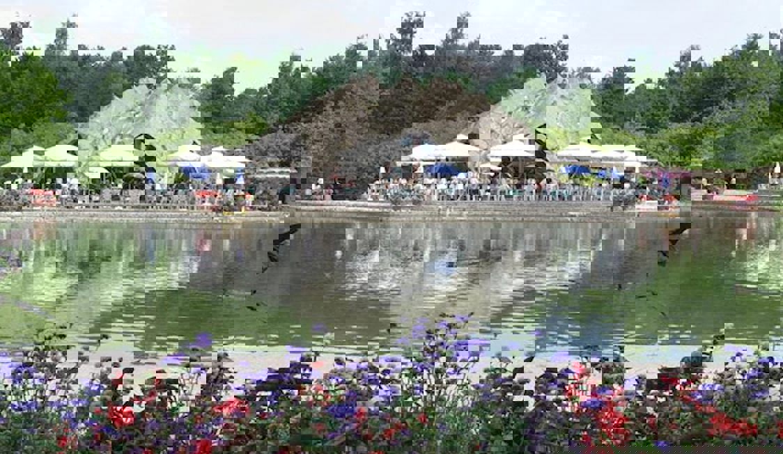 Berlin Britzer Seeterassen i fjärran med spegelblankt vatten i förgrunden.