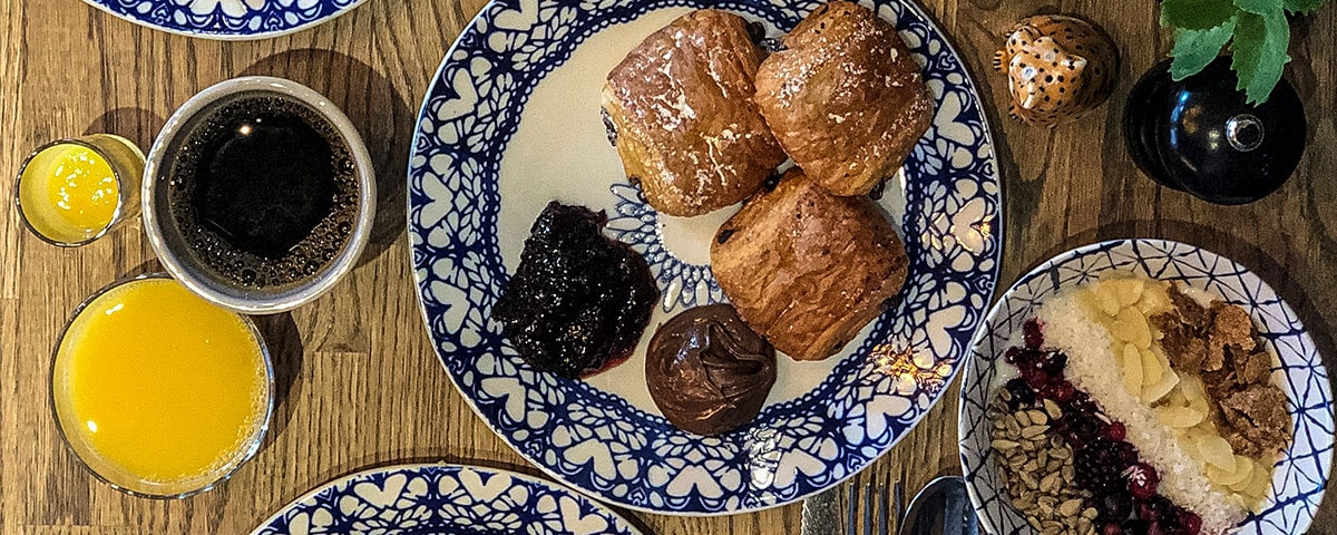 Sort skib sejler gennem vandet med våge i roligt hav set fra luften.