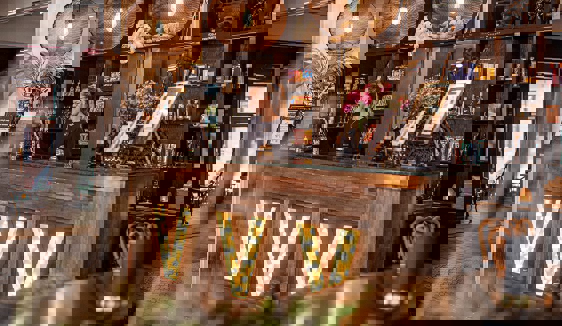 V Hotel reception ses med en kvindelig receptionist.