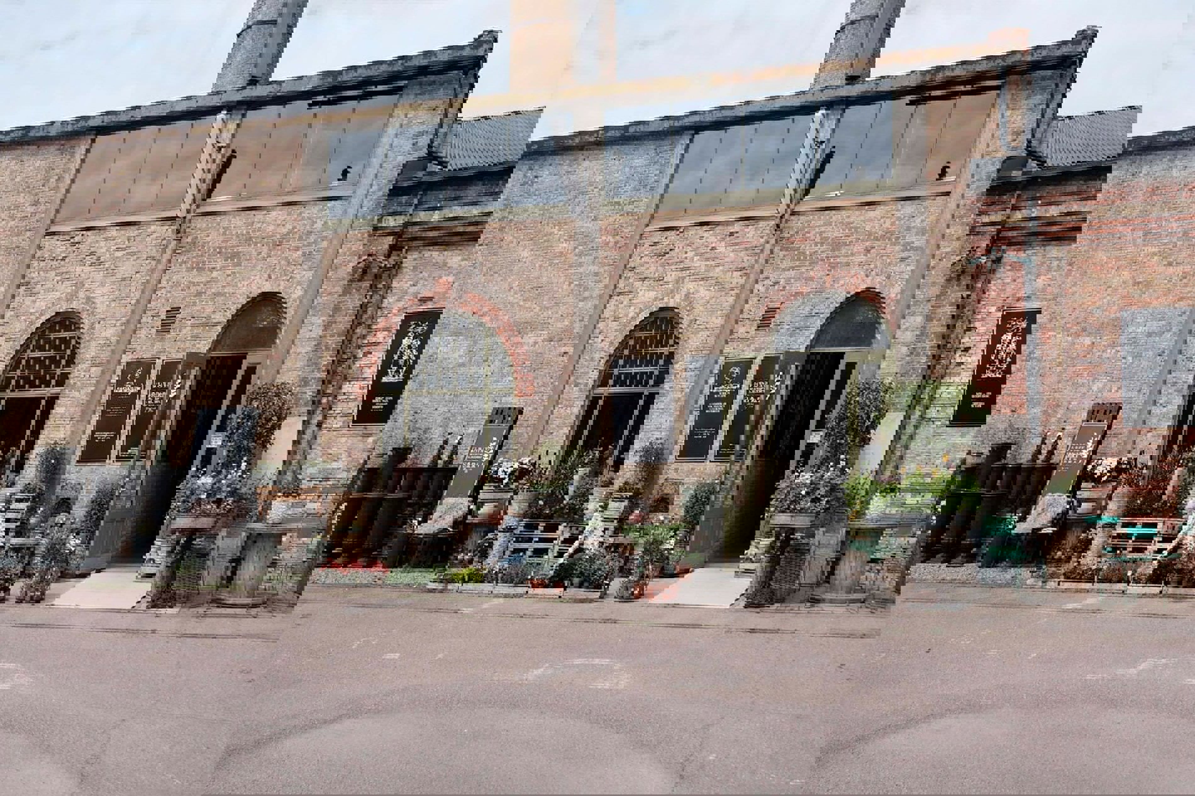 Shoppingcenter Spritfabriken Brygghus set fra gadeplan med tydelige butikskonstruktioner i fokus.