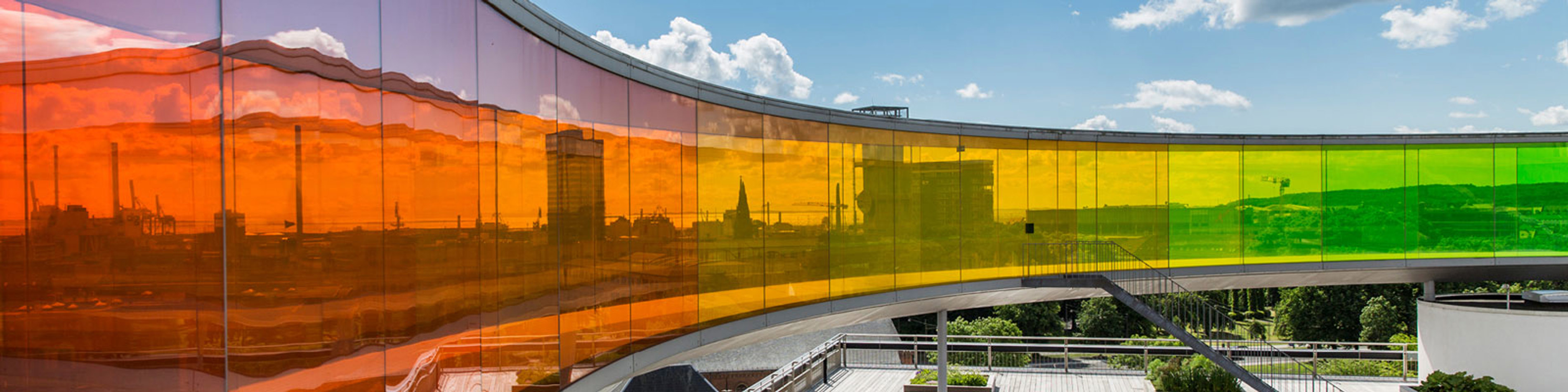 Regnbuepanorama på Aros Kunstmuseum i Aarhus med farverige buede glasvægge set fra taget.